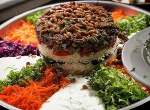 Maklube with lamb meat, almonds and served with rice and salads
